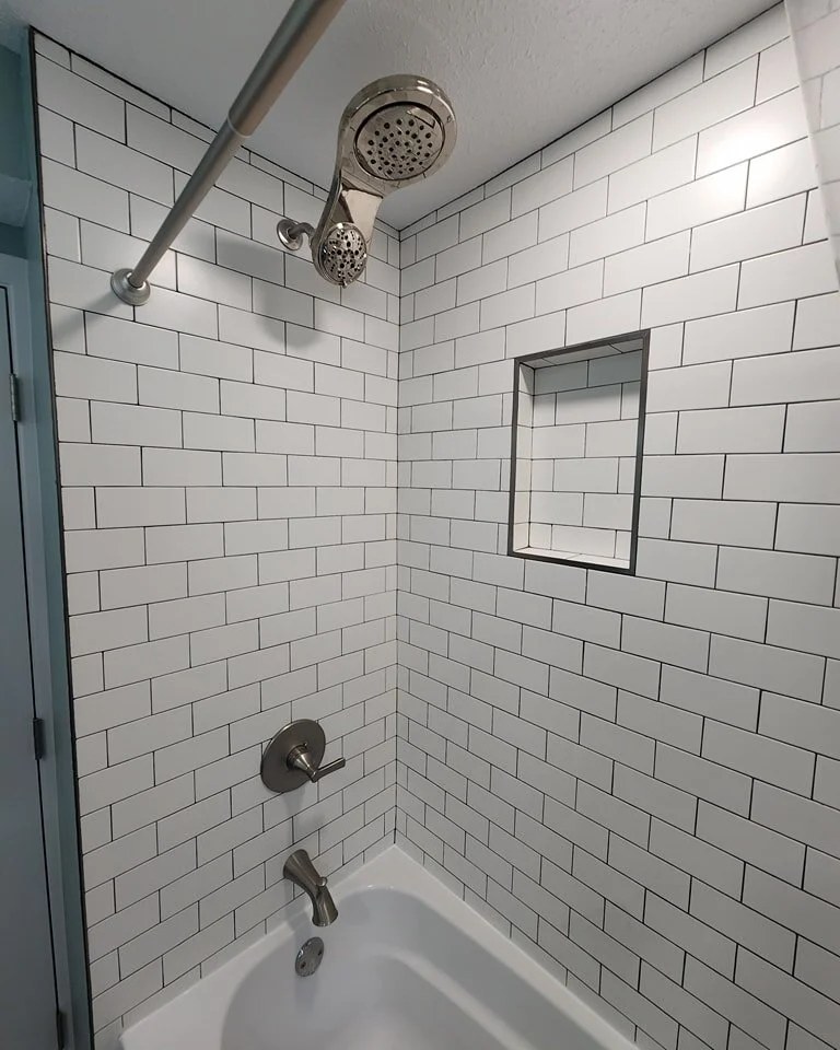 A finished bathroom with a tiled shower and a dark vanity in a house over 100 years old in St. Paul